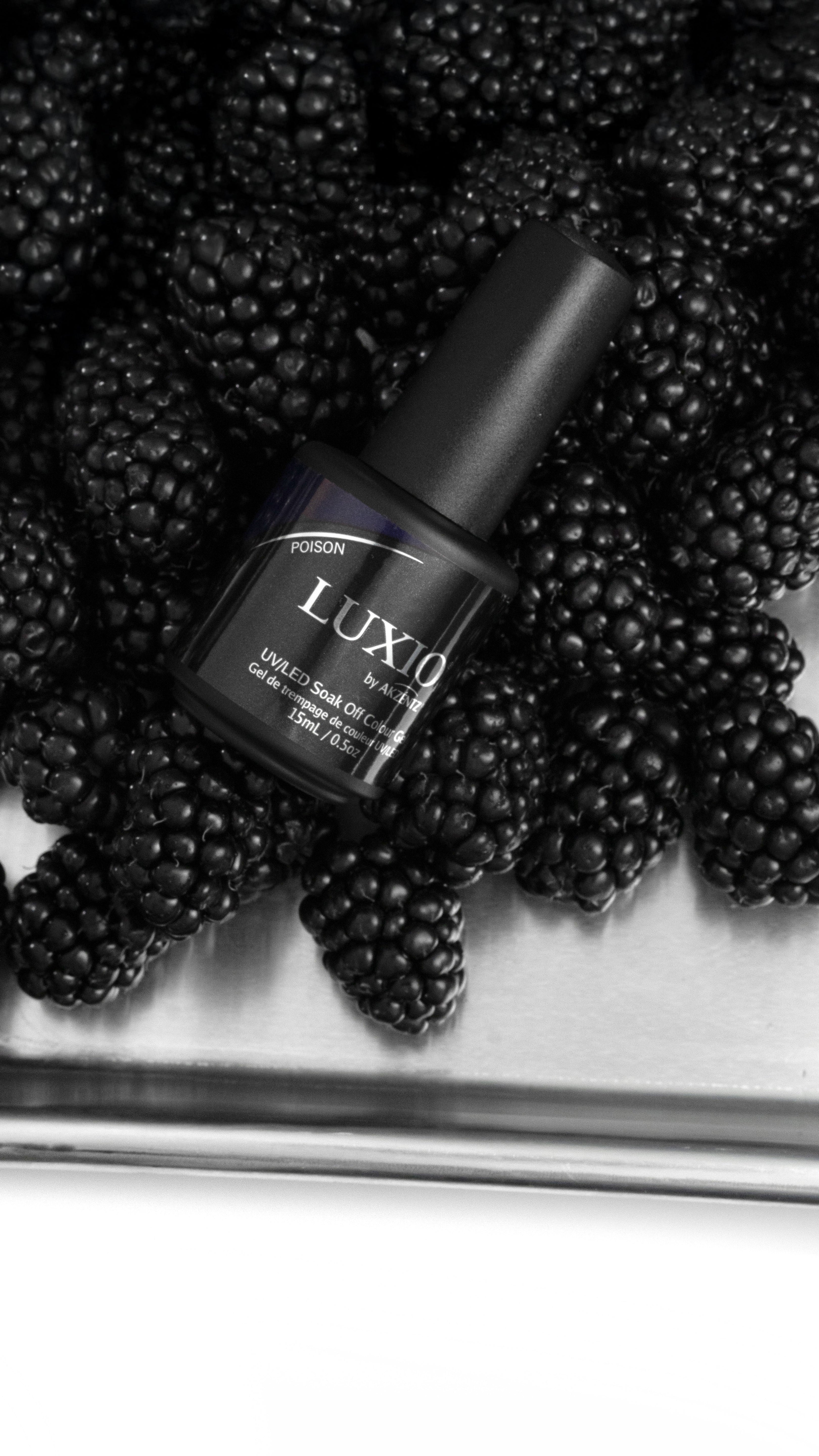 Akzentz Luxio Poison gel bottle among blackberries
