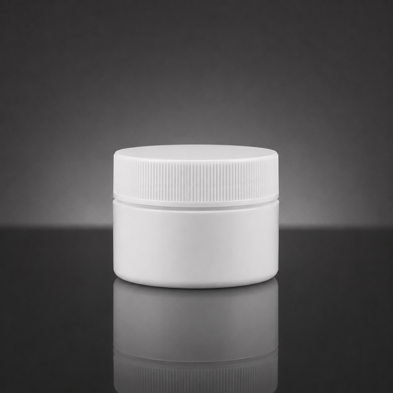A plain white plastic cosmetic jar with a ribbed screw-on lid, centered on a dark gray reflective surface.