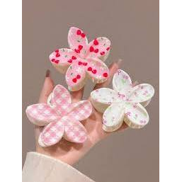 Three Coconoir Beauty assorted patterned flower hair claw clips held in one hand