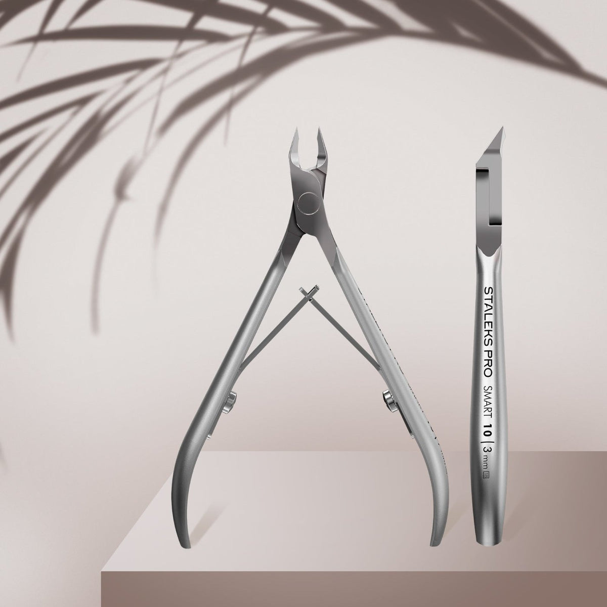 Open Staleks Smart cuticle nippers displayed on a pink product graphic.