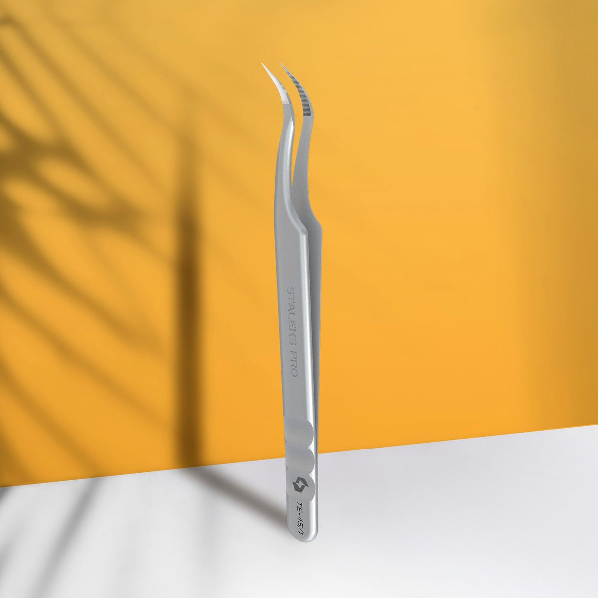 Staleks Volume Curved eyelash tweezers displayed on an orange promotional graphic.
