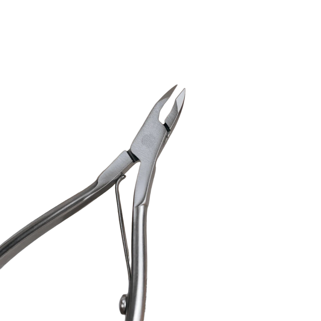 Close-up of the Staleks Classic 12 cuticle nipper jaw beside an orange ribbon.