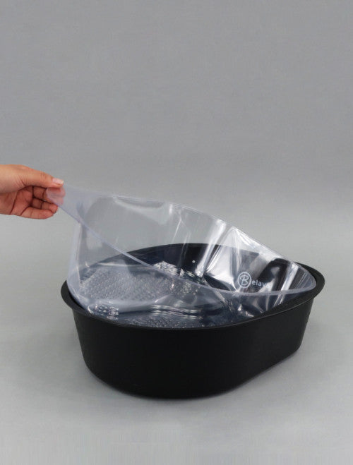 Person holding a clear plastic cover over a black basin on a gray background
