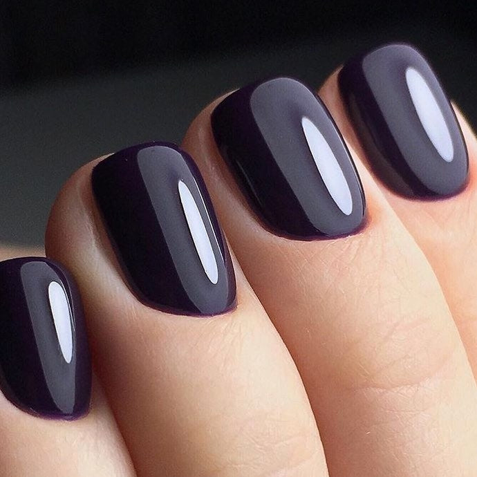 Close-up of glossy deep purple nails wearing Akzentz Luxio Abyss