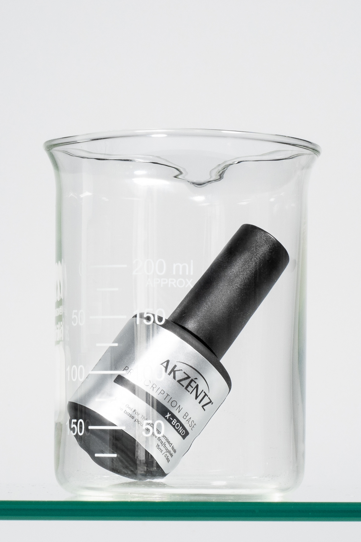Akzentz Prescription Base X-Bond 15ml bottle in glass beaker