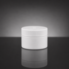 A plain white plastic jar with a ribbed screw-on lid, centered on a dark reflective surface against a gray gradient background.