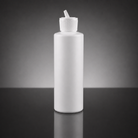 A blank white plastic squeeze bottle with a ribbed screw cap and angled dispensing spout, standing on a dark reflective surface against a dark gray gradient background.