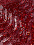 A close-up texture shot of LOONA Midnight Glow Shimmer Builder Gel, showing a glossy, deep red translucent gel base heavily speckled with fine gold and silver glitter.