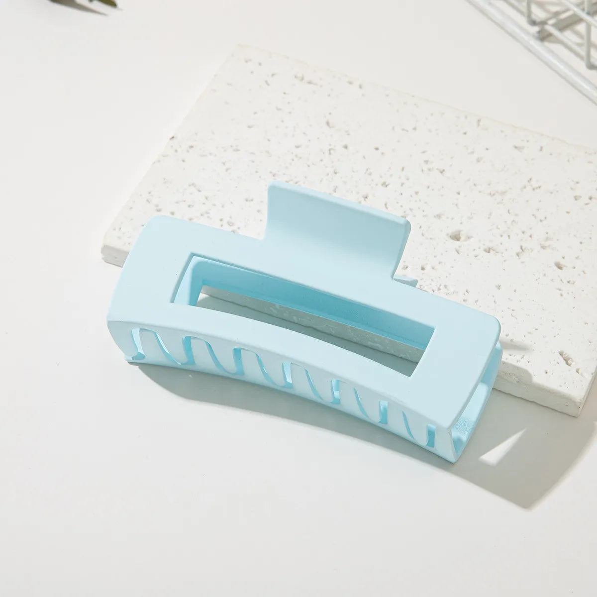 Coconoir Beauty medium light blue rectangular hair claw clip on a pale stone background