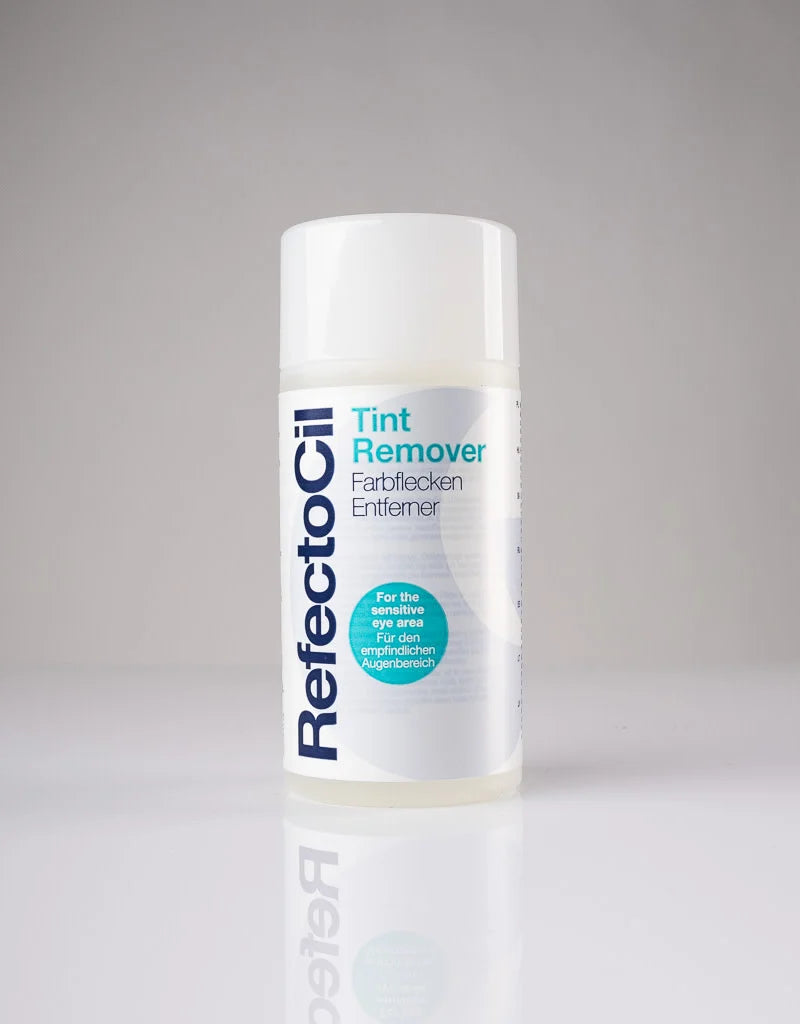 A bottle of RefectoCil Tint Remover fabric cleaner, featuring a white cap and a white label with blue and teal text, set against a neutral gray background with a soft reflection below.