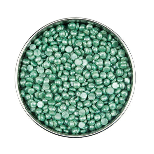 Green beads in a metal bowl on a white background